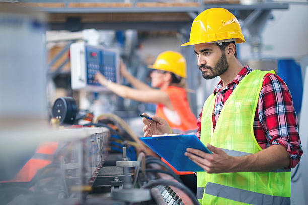 Male worker in factory taking notes stock photo