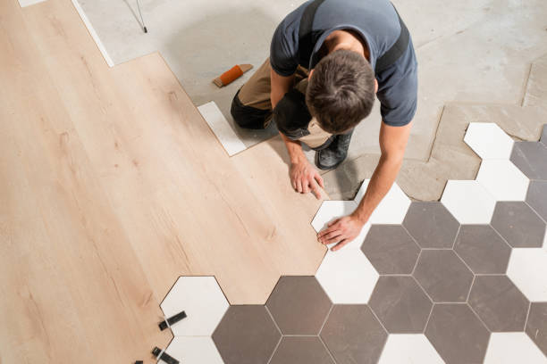 Male worker installing new wooden laminate flooring. The combination of wood panels of laminate and ceramic tiles in the form of honeycomb. Kitchen renovation. The combination of wood panels of laminate and ceramic tiles in the form of honeycomb. Kitchen renovation. home improvement stock pictures, royalty-free photos & images
