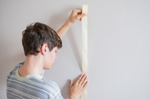 Male Worker Using The Masking Tape To Paint The Wall F Stock