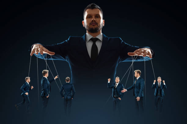 A man, a puppeteer, controls the crowd with threads. The concept of world conspiracy, world government, manipulation, world control. stock photo