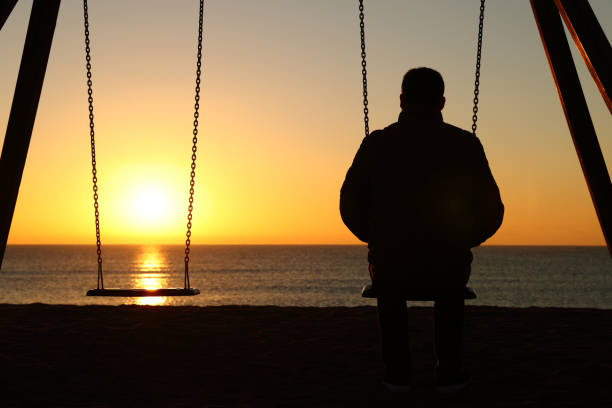 Man alone looking at sunset on the beach Man alone looking at sunset on the beach divorce beach stock pictures, royalty-free photos & images