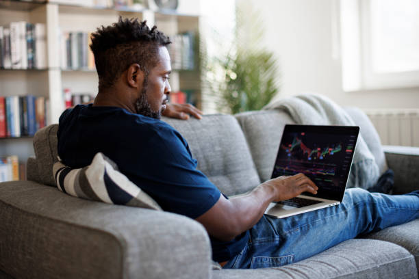 Man analyzing stock market with charts on laptop computer screen at home stock photo