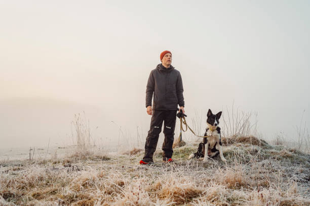 Man and his dog outdoors in rural nature on early morning Man and his dog outdoors in rural nature on early morning
Photo taken in natural light of man in functional clothing and his border collie mixed breed dog early morning dog walk stock pictures, royalty-free photos & images