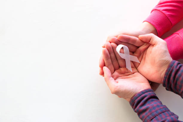 man and woman hold white ribbon - world cancer day imagens e fotografias de stock