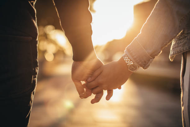 Man and woman holding hands Young couple holding hands holding hands stock pictures, royalty-free photos & images