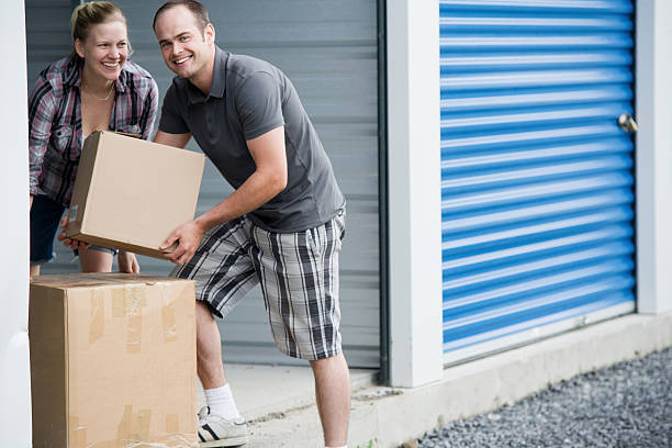 Man and Woman Moving Boxes at Self Storage Unit  self storage stock pictures, royalty-free photos & images
