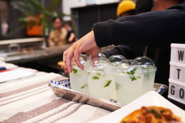 A man arranges a tray of fresh lemonade at a taco stall stock photo