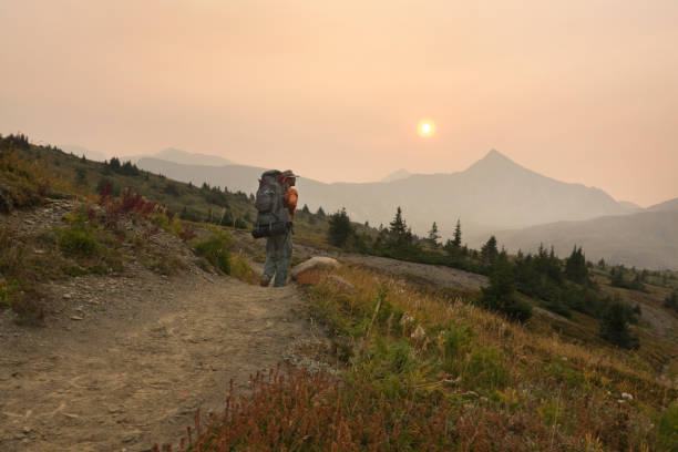 Wildfire smoke fills the morning air in Jasper National Park as the author hikes over the Maccarib Pass.