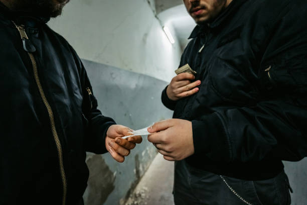 Man Buying Drugs On The Street Addict young man have meeting with dealer at night to buy dose of white powder cocaine. mephedrone stock pictures, royalty-free photos & images