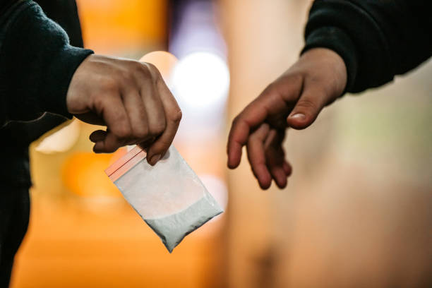 Man Buying Drugs On The Street Addict young man have meeting with dealer at night to buy dose of white powder cocaine. mephedrone stock pictures, royalty-free photos & images
