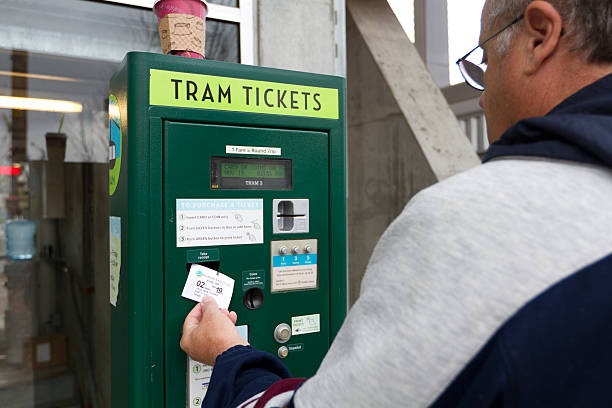 Man Buying Ticket for Unusual Public Transportation "Portland, OR, USA - November 19, 2011: Man purchasing an aerial tram ticket at the bottom of the sky tram to OHSU." neicebird stock pictures, royalty-free photos & images