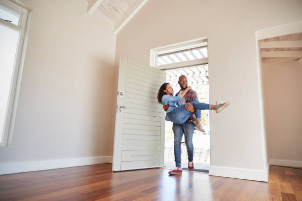 Man Carrying Woman Over Threshold Of Doorway In New Home Man Carrying Woman Over Threshold Of Doorway In New Home newlywed stock pictures, royalty-free photos & images