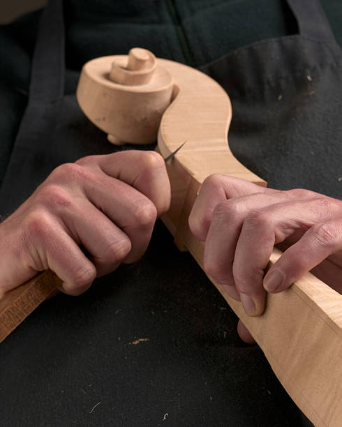 man carves instrument stock photo