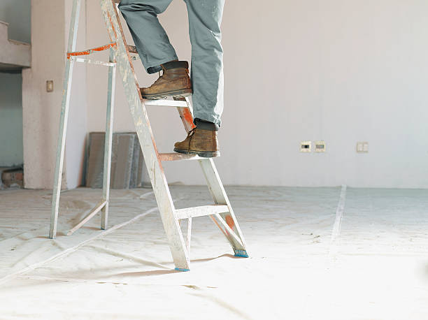 Man climbing ladder in unfinished room  ladder stock pictures, royalty-free photos & images