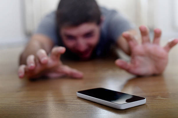 man creeping on ground smart phone and internet addiction concept stock photo