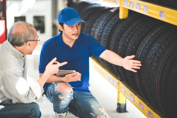man customer client choosing and buying a retail tire at automobile sale shop store, transport garage car wheel business service, auto mechanic rubber tyre maintenance stock photo