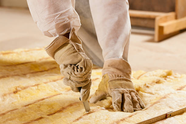 Man cutting insulation material for building construction stock photo