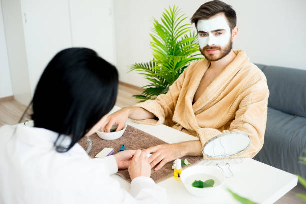 Man doing manicure A spa worker does a manicure for a handsome man man pedicure stock pictures, royalty-free photos & images