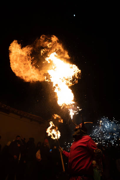 Man dressed as a demon spitting fire through his mouth during Spanish traditional festival, called Correfoc stock photo