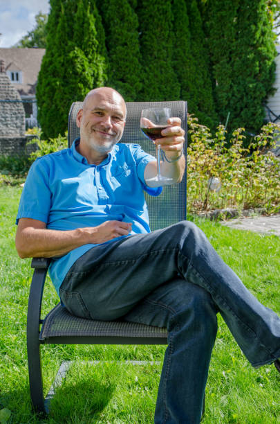 Man drinking wine in his backyard stock photo