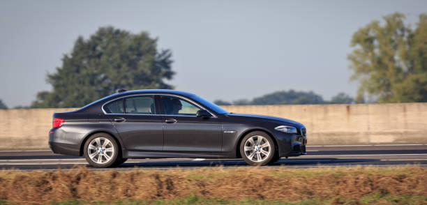 man rijdt grijze bmw 520i op rijksweg a35 bij wierden - bmw stockfoto's en -beelden