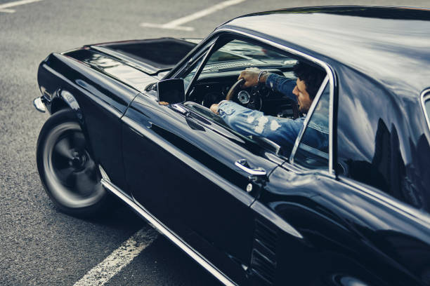 A man driving old black classic car stock photo