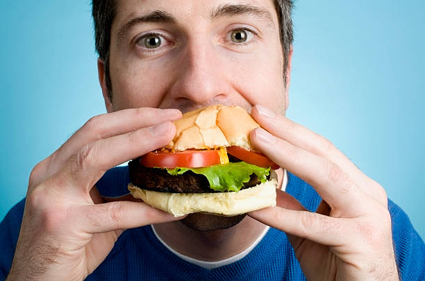 человек ест гамбургер - fat guy eating a burger backgrounds стоковые фото и...