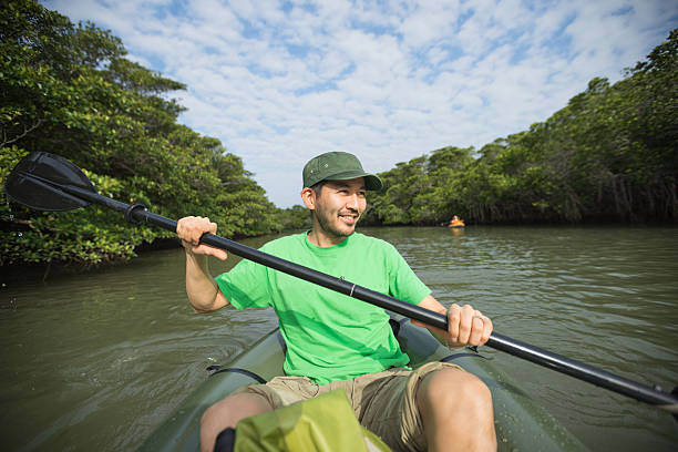 homme en kayak dans la mangrove river, japon - kayak mangrove photos et images de collection