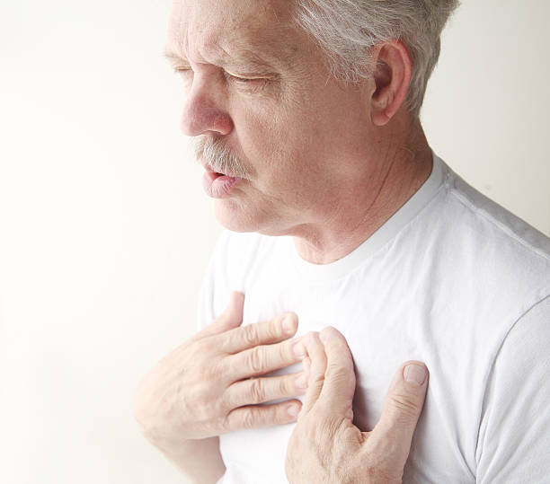 man exhales with hands on chest stock photo