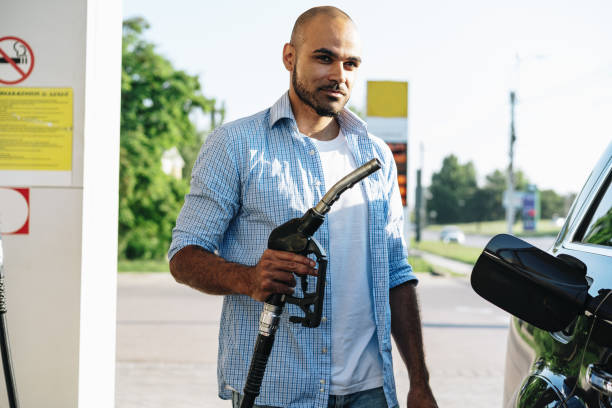 hombre que llena combustible de gasolina en coche en gasolinera - gas pump fotografías e imágenes de stock