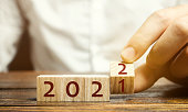 istock Man flips a block changing 2021 to 2022. New year beginning. Holidays and Christmas. Trends and changes in the World. Build plans and goals. New normal. Summing work done. 1299822012