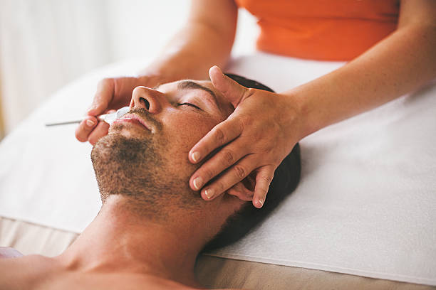 Man getting a face treament at the health spa stock photo