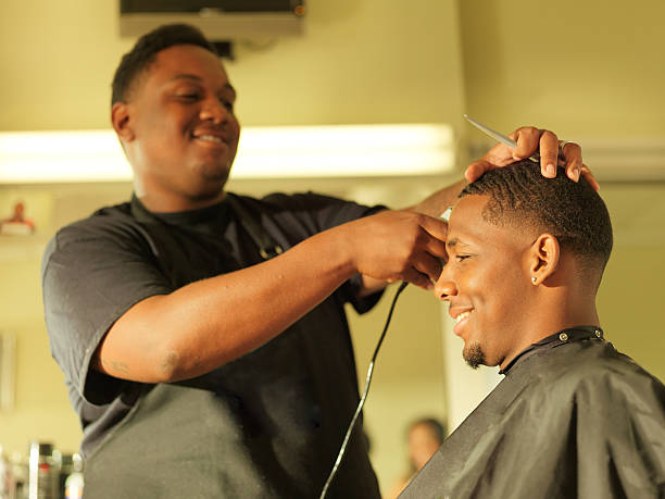 man getting his hair cut at barber shop stock photo