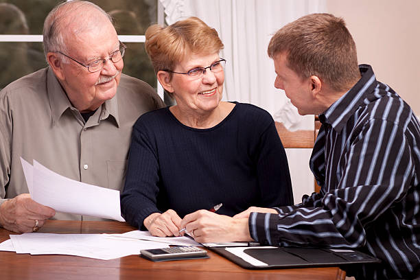 Man giving financial advisor to senior couple smiling stock photo