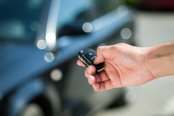 man hand unlocking car Man hand press the remote control car alarm systems car rental stock pictures, royalty-free photos & images