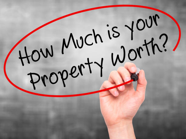 Man Hand writing How Much is your Property Worth? with black marker on visual screen stock photo