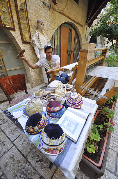 Man handmaking tallits and yamakas in Jerusalem, Israel stock photo