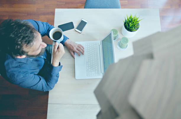 Man having a coffee brake while working from his home stock photo