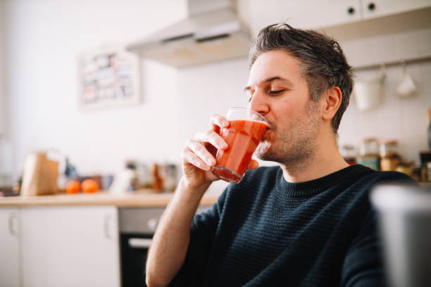man having a fruit smoothie for breakfast at his home stock photo