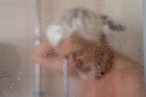 Man having a shower at home stock photo