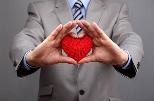 발렌타인 데이, 비즈니스 고객 관리, 자선, 사회적 및 기업의 책임을 위해 빨간 모직 심장 개념을 들고있는 남자 - 사회적 책임 이미지 뉴스 사진 이미지