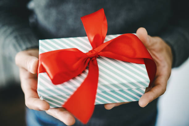 Man holding gift with red ribbon stock photo