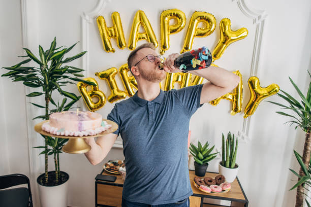 Man holding his birthday cake One man, male holding his birthday cake on his birthday party. happy birthday wine bottle stock pictures, royalty-free photos & images