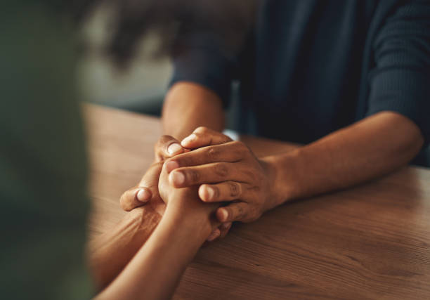 Man holding his girlfriend's hand Close-up of man holding his girlfriend's hand over the wooden table affectionate stock pictures, royalty-free photos & images