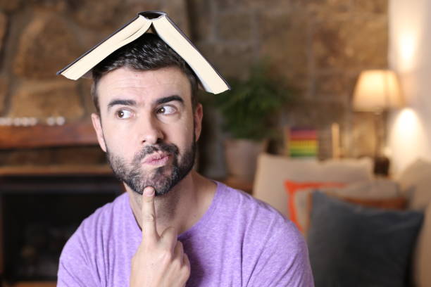 Man holding open book over head stock photo