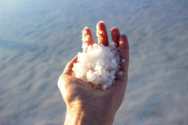 Man holding salts in salt lake in Aksaray, Turkey stock photo