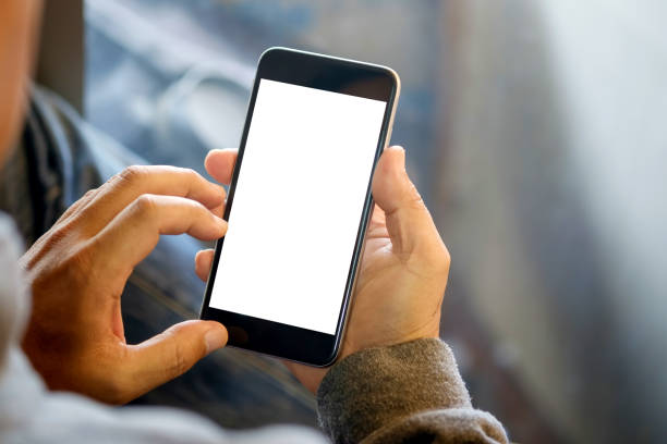 man holding smart phone with blurred background. - segurar imagens e fotografias de stock