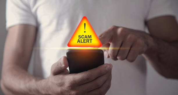 Man holding smartphone. Scam Alert Man holding smartphone. Scam Alert white collar crime stock pictures, royalty-free photos & images
