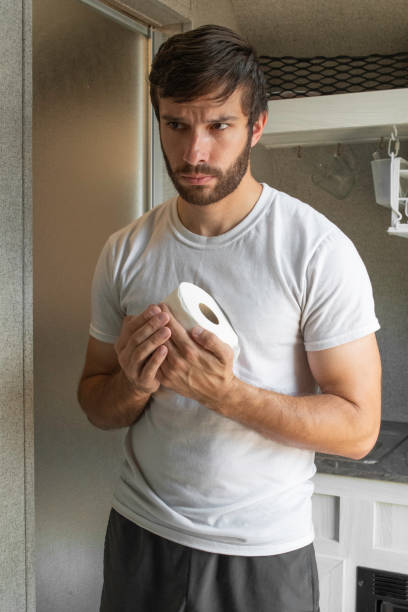 A man holds toilet paper stock photo