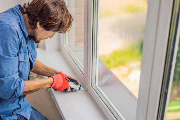 Man in a blue shirt does window installation Man in a blue shirt does window installation. insulation stock pictures, royalty-free photos & images